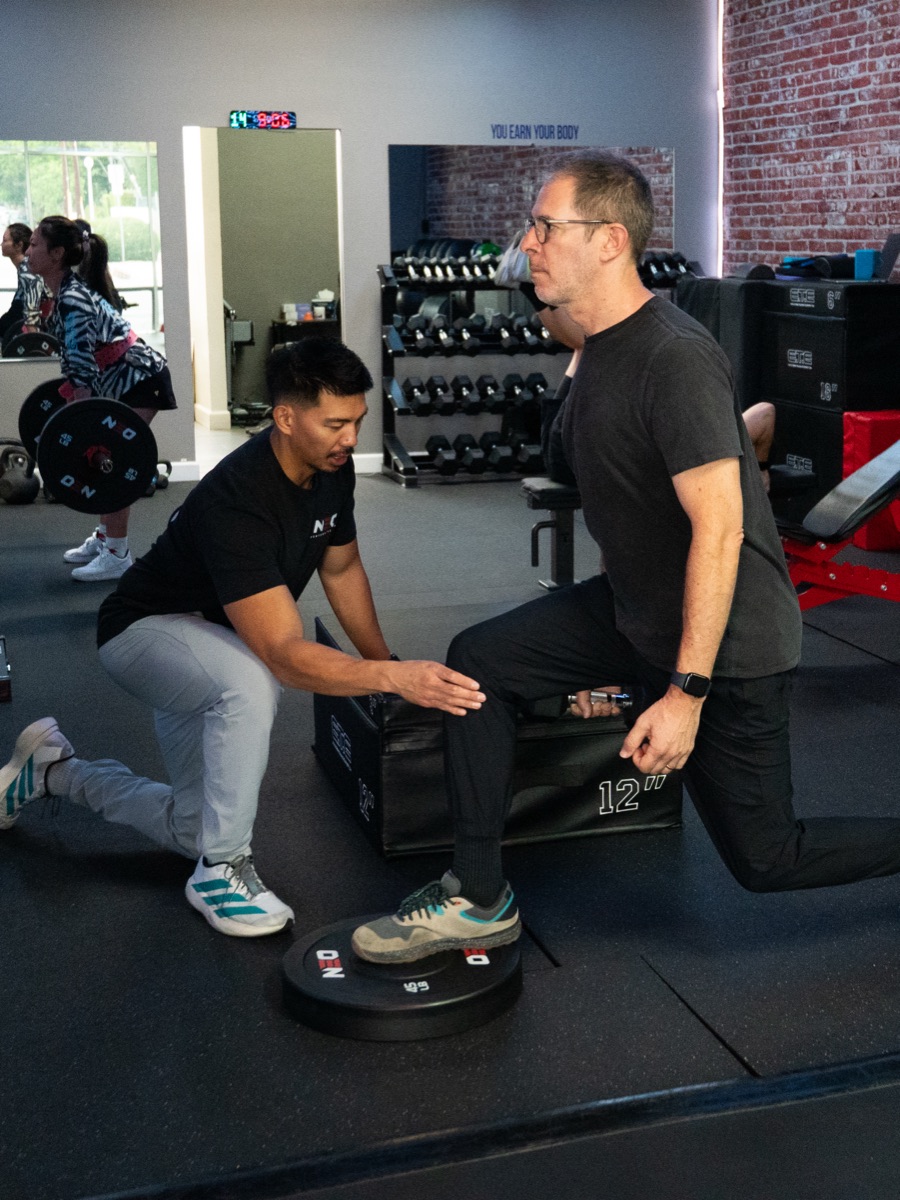 A NEO coach guiding a client through a step-up exercise