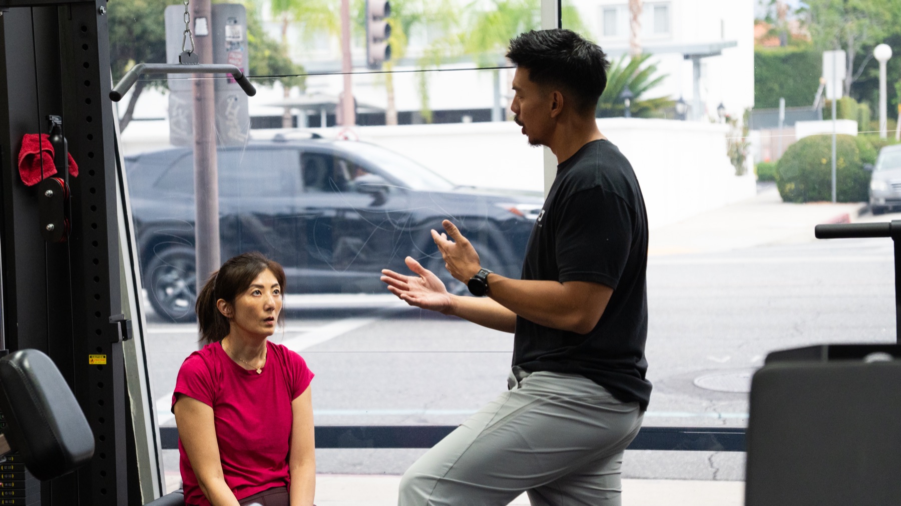 A NEO coach working with a woman beside the Pasadena studio windows
